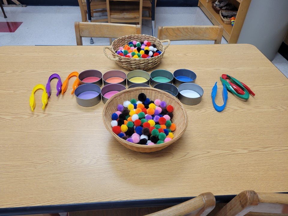 4 & 5 year old math table with sorting pom poms.