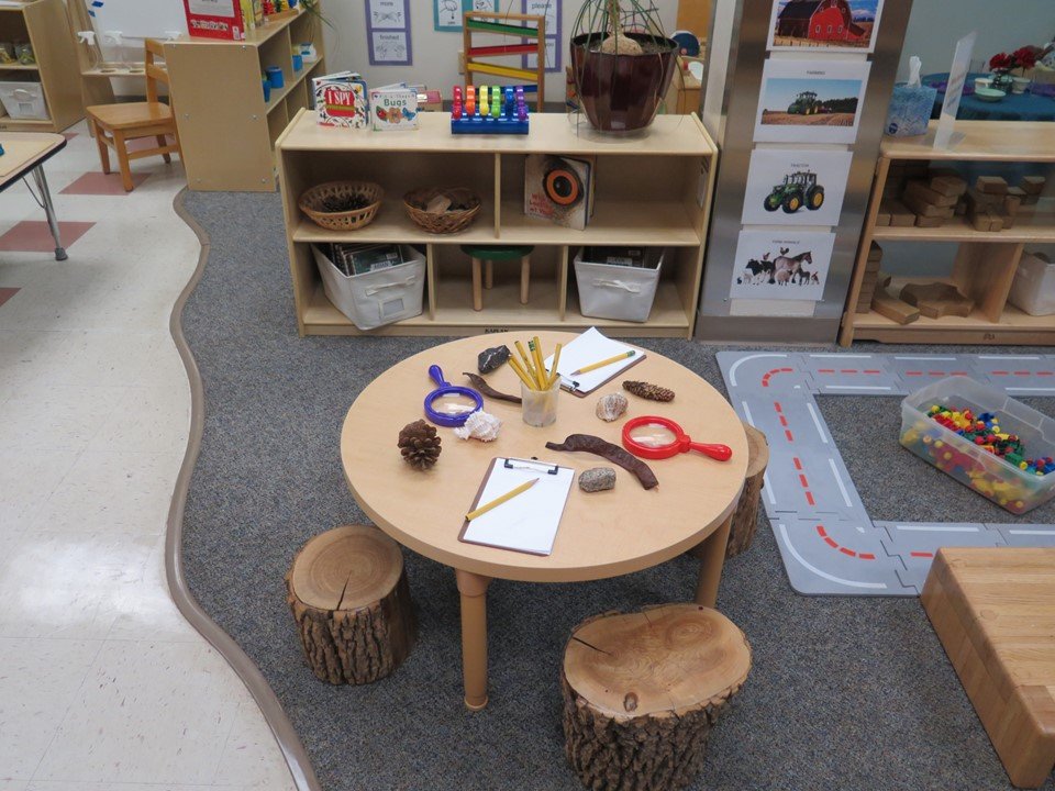 Toddler science area with table, magnifying glasses and items to examine.
