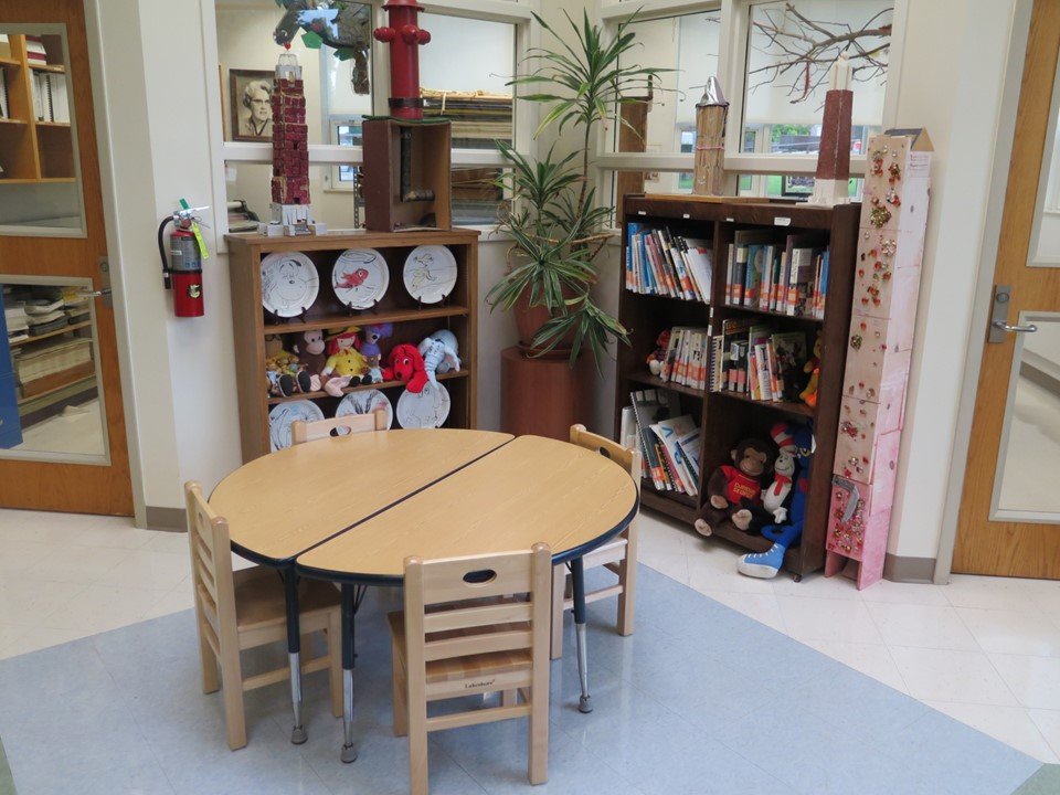 A small work space for a group of children in the gathering space. It includes a table and four chairs.