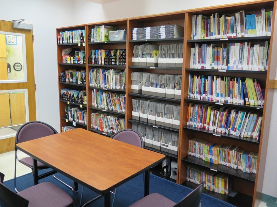 This is the K-3 reading room with a table and many different types of books.