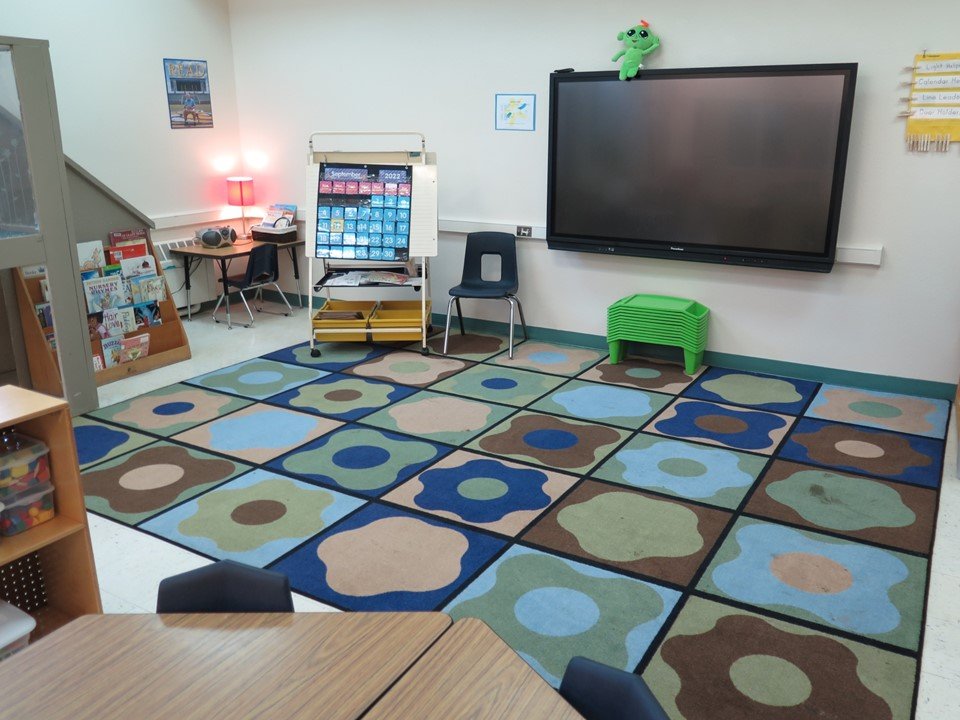 This is the Kindergarten group time area with a large rug, smart board and teaching easel.