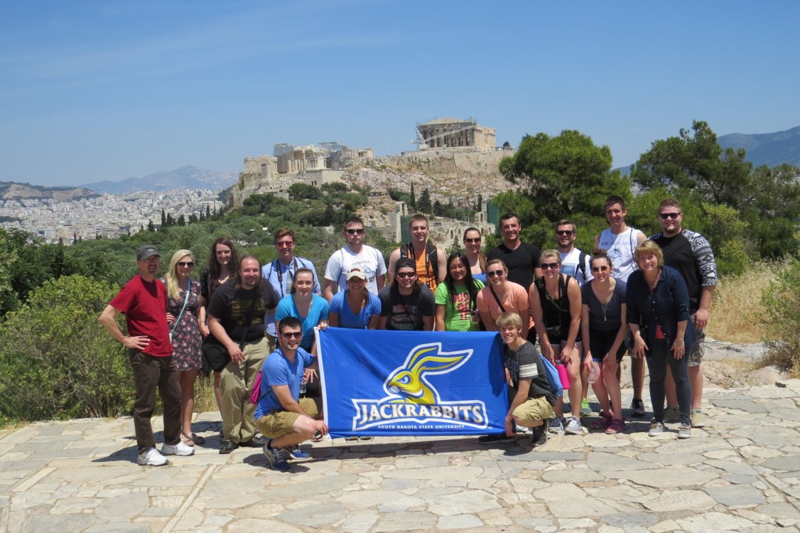 Fishback Honors College students with the SDSU Jackrabbit flag in Greece