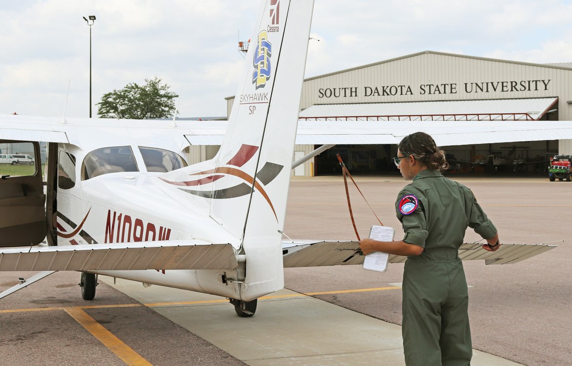 Student inspecting a plane