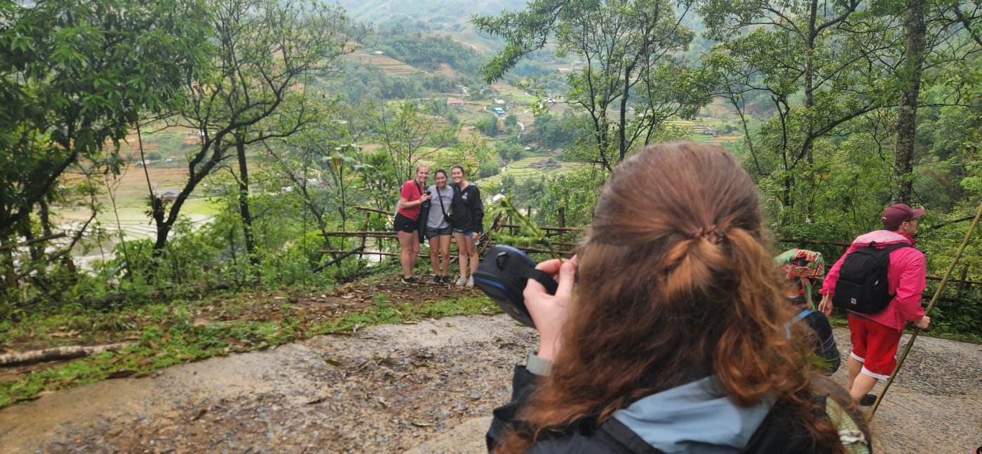 An Honors student taking a picture of her classmates in front of the Sapa rice fields in Vietnam
