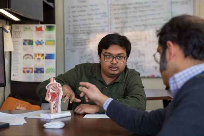Doctoral student Mohammad Mehedi Hasan Akash, left, pointing to a human head model with a cutout of the upper airways and asst. prof Basu on right - side view