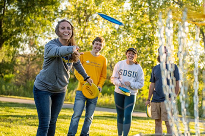 Students playing disc golf at SDSU's disc golf course