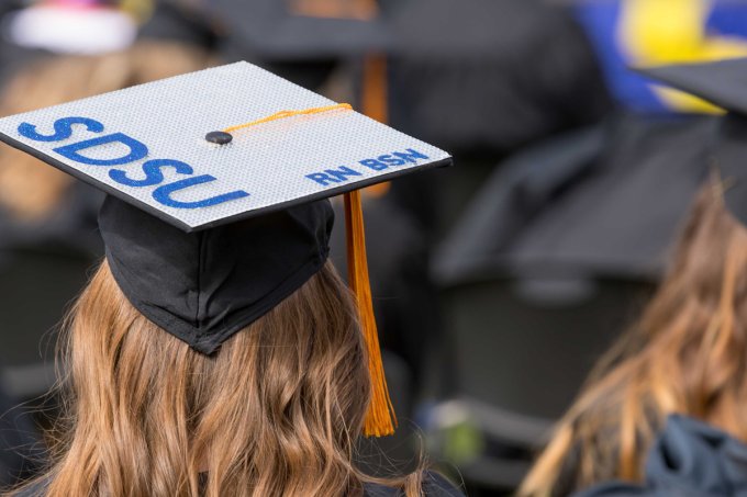 Student wearing a graduation cap that says "SDSU RN BSN"