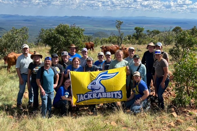 Group photo of class in South Africa holding SDSU Jackrabbits flag