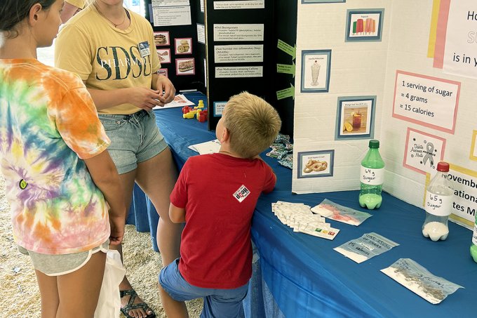 An SDSU pharmacy student provides education to a South Dakota State Fair attendee.