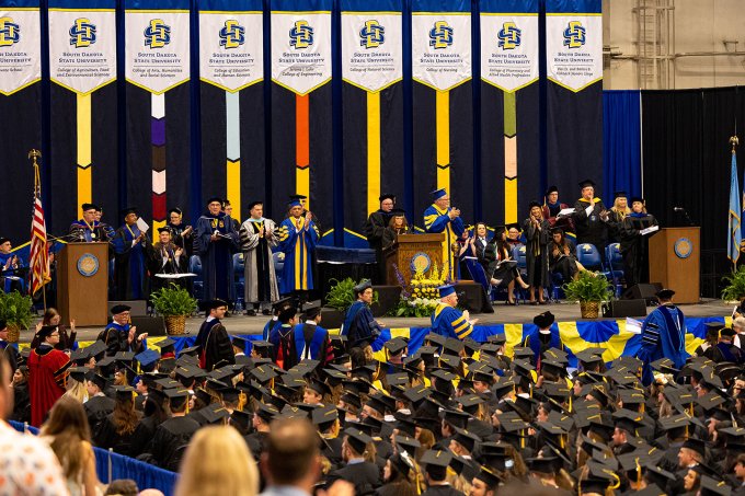 South Dakota State University graduates, officials and dignitaries are shows at a spring 2023 commencement ceremony at the Dakotah Bank Center in Brookings.