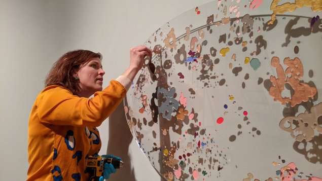 Molly Wicks installing her artwork at the South Dakota Art Museum