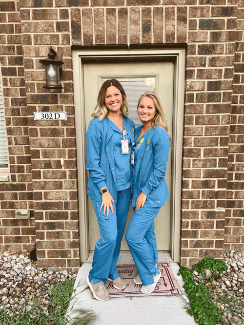 Two nursing students in scrubs.
