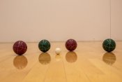 2 red and 2 green bocce balls with 1 white ball in the middle