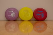 3 different colored frisbees used for disc golf