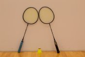 2 badminton rackets with one birdie in the middle