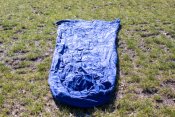 Blue sleeping bag liner laying in the grass