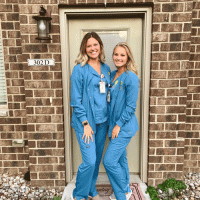 Two nursing students in scrubs.