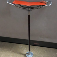 Opened "shooting stick" or folding chair with a red leather seat.