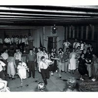 A black and white photo of a group of people dancing at Camp Lakodia in South Dakota in 1952 