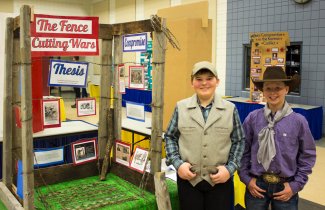 "NHD in SD Student's posing with their exhibit board titled 'The Fence Cutting Wars."""