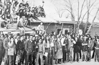 "Native American activists during the Wounded Knee Occupation. A sign above the door in the background reads “Independent Oglala Nation Wounded Knee.”"
