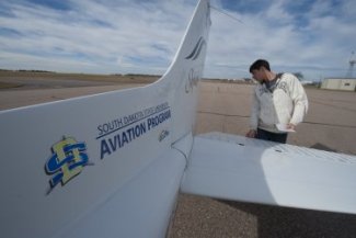 Student checking airplane before flying.