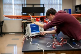Electrical engineering student working on a project in the lab.