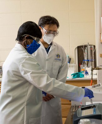 Augustina Osabutey, left, and assistnat professor Xufei Yang using machine to determine chemical oxygen demand