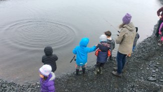 group of kids fishing by the water