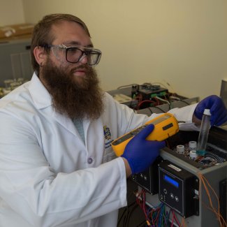 Doctoral student Kyle Burch uses thermal camera to measure temperature in a prototype device