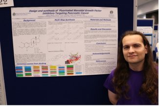 Student Axel Irianni standing next to her poster.