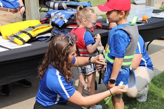 Kids try on life jackets with the help of South Dakota State University nursing students at a health fair at the Great Plains Zoo in Sioux Falls on June 16.