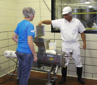 Vikram Mistry assists a student member of the SDSU Dairy Club prepare cheese boxes for their annual fundraiser.
