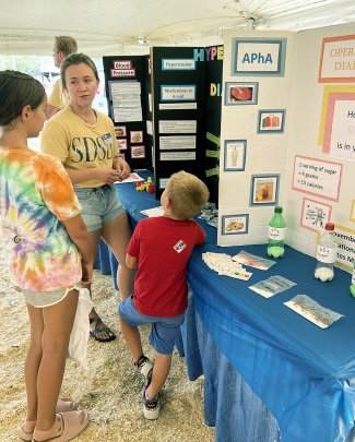 An SDSU pharmacy student provides education to a South Dakota State Fair attendee.