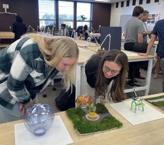 SDSU students look at glyphs designed during the creation of a new campus model in the School of Design.