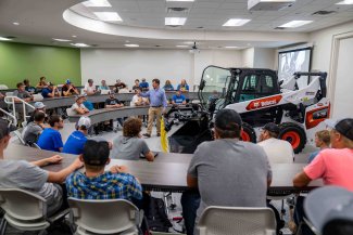 An SDSU professor teaches in front of piece of equipment in the Raven Precision Ag Center.