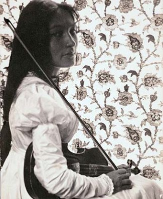 Zitkala-Ša, having grown her hair back out after her stay at the missionary school, and her violin.
