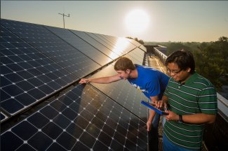 Two students working on a solar panel array.