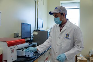 Graduate student Md Saddam Hossain loads a sample into a flow cytometer